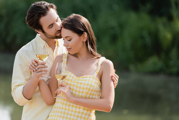 romantic couple in summer clothes holding glasses with wine - Φωτογραφία, εικόνα