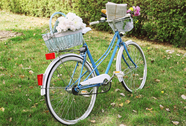 Bicycle with flowers in basket - Fotoğraf, Görsel