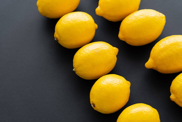Flat lay of juicy and bright lemons on black background  - Foto, Imagen
