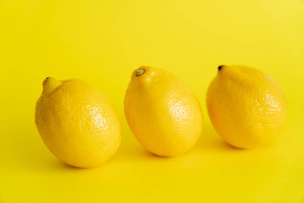Organiczne cytryny na żółtej powierzchni z przestrzenią do kopiowania - Zdjęcie, obraz