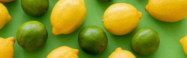 Top view of juicy lemons and limes on green background, banner  - Фото, изображение