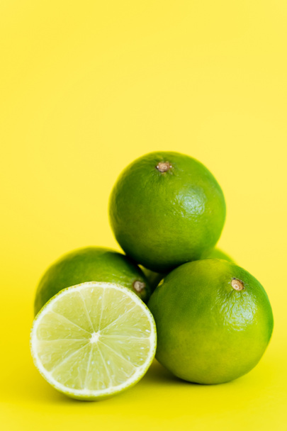 Close up view of half and limes on yellow background  - Fotó, kép