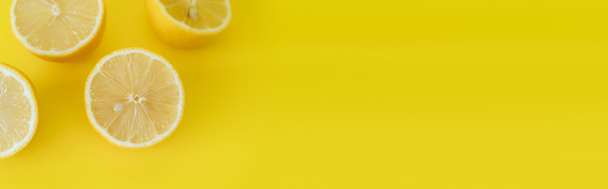 Top view of juicy halves of lemons on yellow background with copy space, banner  - Fotó, kép
