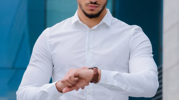 Неузнаваемый бизнесмен босс менеджер босс носит белую официальную рубашку смотрит на наручные часы сердитый в последнее время опоздание проверяет час негативное расстройство поздняя встреча с партнером - Фото, изображение