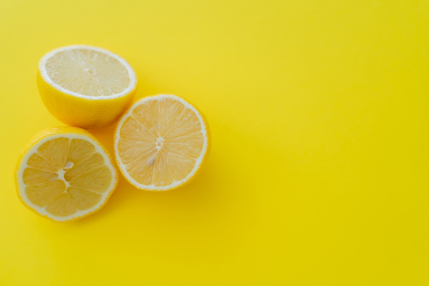 Top view of halves of lemons on yellow background - Zdjęcie, obraz