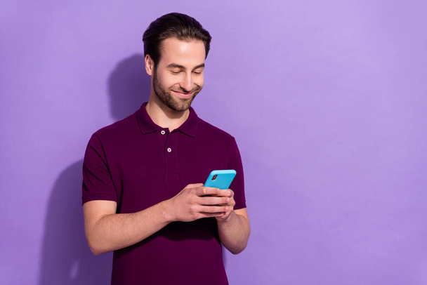 Portrait of positive young man influencer writing post blog share his lifestyle story isolated on purple color background - Photo, Image