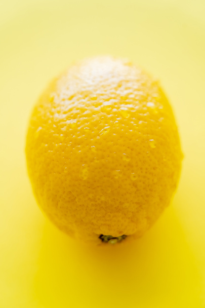 Close up view of wet lemon on yellow background  - Photo, Image