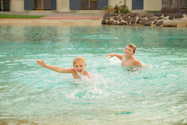 Kinderen zwemmen in de Settlement Cove Lagoon zwembad in Redcliffe, Queensland Australië - Foto, afbeelding