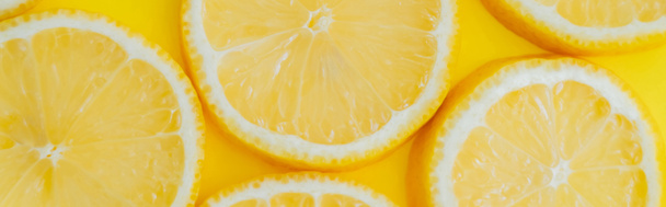黄色の背景にスライスされたレモンのトップビュー、バナー - 写真・画像