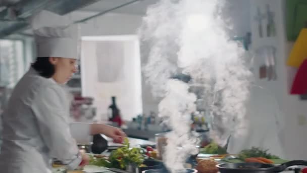 Mujer que usa sartén para cocinar verduras en la cocina - Imágenes, Vídeo