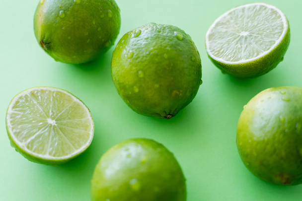 Close up view of ripe limes with water drops on green background - Foto, immagini