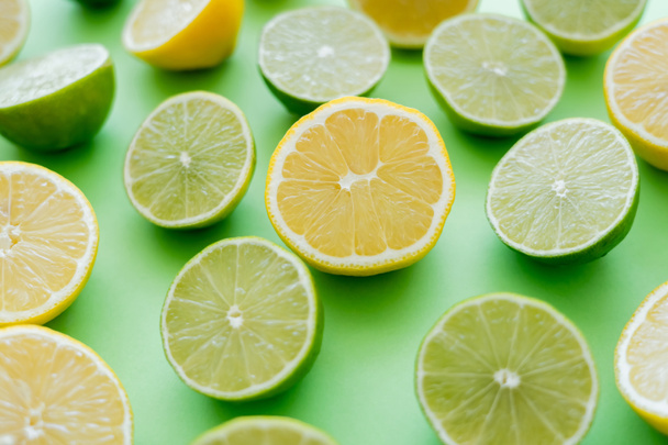 Close up view of cut and juicy citrus fruits on green background - Fotografie, Obrázek