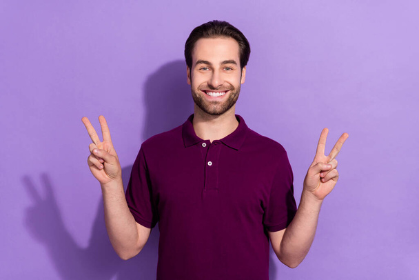 Photo of handsome attractive male showing v-sign wear trendy fashionable t-shirt isolated on purple color background - Foto, Bild