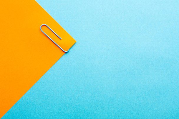Minimalist background with blue paper clip on colorful background with free copy paste space for text. - Photo, Image