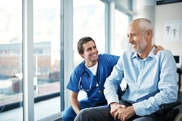 Its my job to keep you happy and well. Shot of a male nurse caring for a senior patient. - Foto, imagen