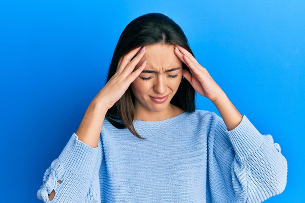 Молодая испаноязычная девушка носит повседневную одежду с рукой на голове от боли в голове, потому что стресс. страдает мигренью.  - Фото, изображение