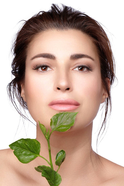 Φυσική ομορφιά με πράσινα φύλλα Όμορφη γυναίκα με άψογη επιδερμίδα και γυμνό μακιγιάζ στην ενυδατωμένη και λαμπερή επιδερμίδα της. Φυσικά καλλυντικά και skincare έννοια. απομονώνονται σε λευκό με αντίγραφο χώρου - Φωτογραφία, εικόνα