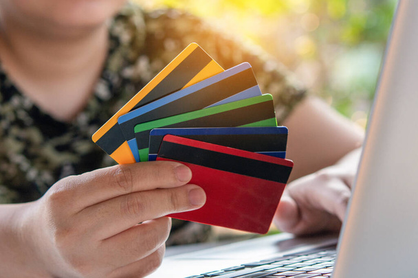 Płatność kartą kredytową. Kobieta trzyma kartę kredytową i używa laptopa. Zakupy online - Zdjęcie, obraz