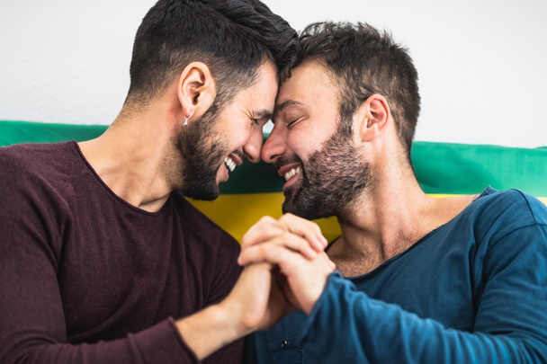 幸せなゲイのカップルがベッドでロマンチックな瞬間を持っています-同性愛の愛関係とジェンダー平等の概念 - 写真・画像