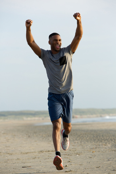 Здоровий молодий чоловік біжить з піднятими руками
 - Фото, зображення