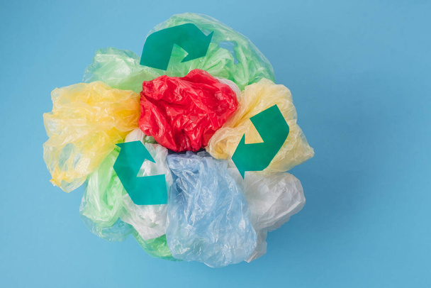 Recyklační značka na plastové tašky a plastové zábaly různých barev na modrém pozadí. žádný plastový koncept. Kvalitní fotografie - Fotografie, Obrázek