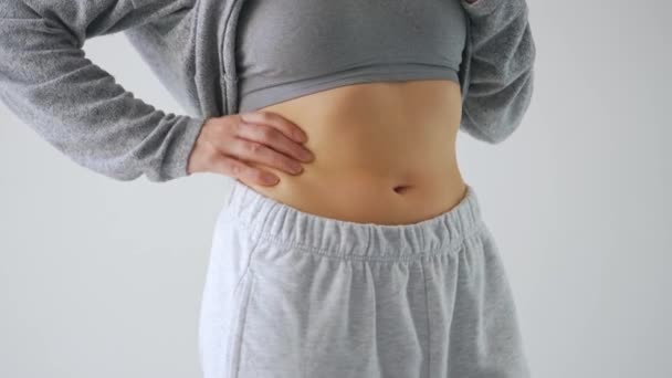 Kobieta ściskająca skórę na brzuchu, sprawdzająca nadmiar tłuszczu podskórnego - Materiał filmowy, wideo