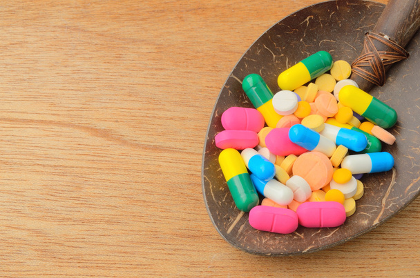 píldora de la cápsula de medicina colorida en cuchara
 - Foto, imagen