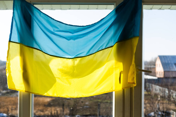 Flaga Ukrainy na oknie zapieczętowanym taśmą. Żadnej wojny. Wojna na Ukrainie - Zdjęcie, obraz