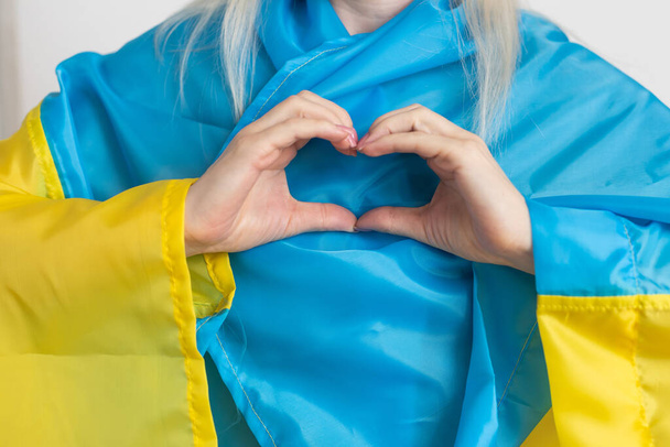 Hands of a heart on the background of the flag Ukraine. Ukraine against the war. Stop war in Ukraine. - Photo, Image