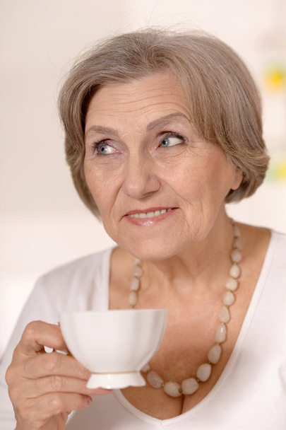 Older woman drinking tea - Valokuva, kuva