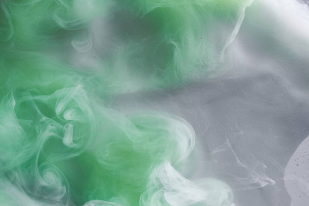 Zöld füst fehér tinta háttér, színes köd, absztrakt örvénylő smaragd óceán tenger, akril festék pigment víz alatt - Fotó, kép