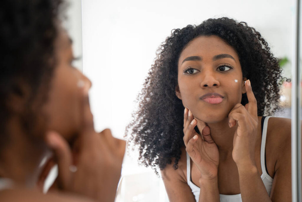 One black woman looking skincare mirror - Fotó, kép