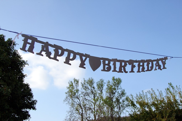 μεγάλη πινακίδα Happy Birthday κρεμασμένα από το γαλάζιο του ουρανού - Φωτογραφία, εικόνα