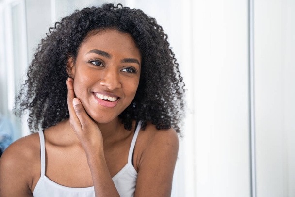 One black woman smiling in front of mirror - Фото, зображення