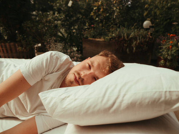 Man sleeping on bed in bedroom at home blond grain effect - Foto, Imagem