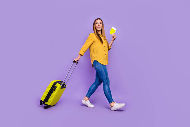 Full size photo of cheerful young lady go on vacation departure in airport isolated on violet color background - Photo, Image