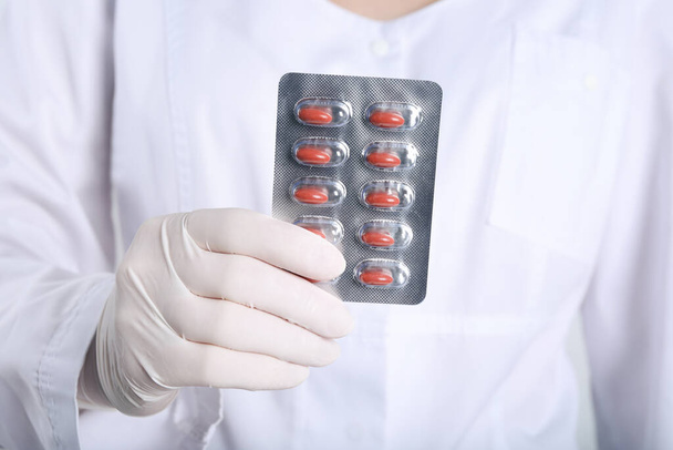 Doctor holding red pills, closeup. Anemia treatment - Fotoğraf, Görsel
