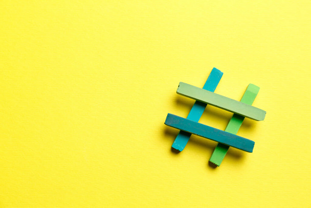 Hashtag symbol made of colorful chalks on yellow background, top view. Space for text - Foto, Imagem