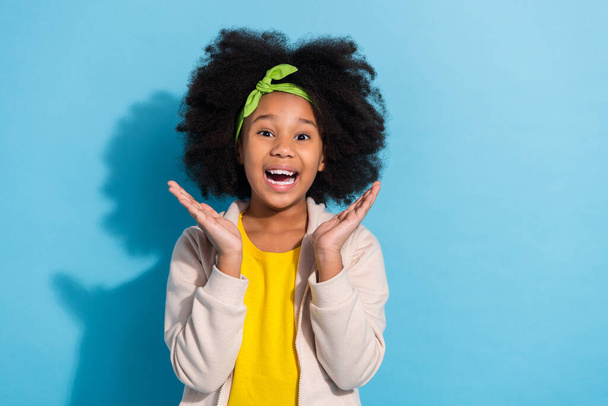 Portrait of attractive amazed cheerful girl schoolkid having fun great news isolated over bright blue color background - Fotó, kép