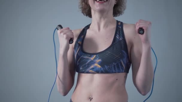 Fit woman with jump rope posing in the gym. Sport exercises healthy lifestyle concept. Sporty happy woman with skipping rope posing to the camera. Active lifestyle concept. Healthy lifestyle - Footage, Video