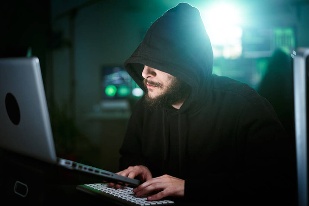 Homem hacker fazendo um ataque de computador começando a digitar no teclado do laptop e quebrando a senha. Homem a invadir sistemas de segurança. Freelancer usando cibercrime laptop - Foto, Imagem