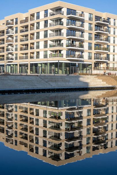 Neues Mehrfamilienhaus in Berlin, Deutschland, spiegelt sich in einem kleinen Kanal - Foto, Bild