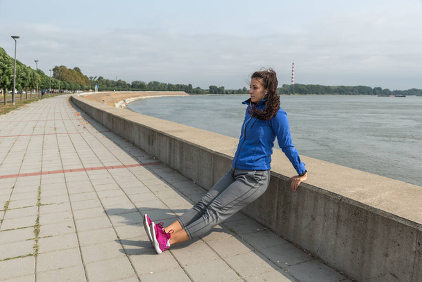 Young woman starting new life after car crash accident or heavy illness with morning routine of exercising running and jogging outdoor. Female sport person stretching muscles before workout. - Фото, зображення
