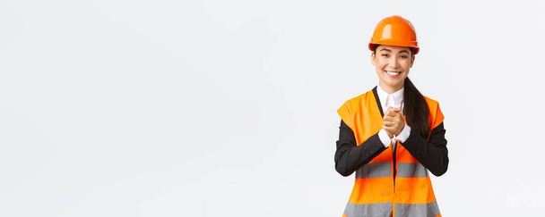 Ringraziato successo asiatico architetto donna salutare gli investitori o clienti in zona di costruzione, indossando casco di sicurezza e giacca, stringendo le mani strette in apprezzamento, essere grati per la fiducia - Foto, immagini