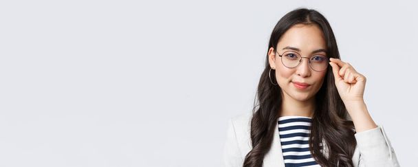 Business, finance and employment, female successful entrepreneurs concept. Close-up of confident young asian businesswoman fixing glasses and looking determined, ready to sign deal - Fotografie, Obrázek