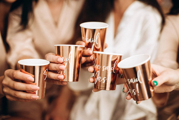 Girls hold golden paper cups - Valokuva, kuva