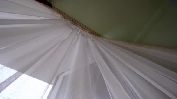 átlátszó függöny az ablakon, enyhén lengve a szélben a szobában. - Felvétel, videó