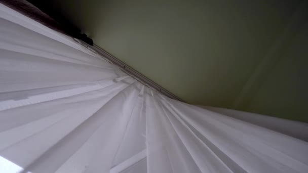 una cortina transparente en la ventana, ligeramente balanceándose en el viento en la habitación. - Metraje, vídeo