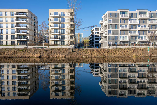 Moderne Mehrfamilienhäuser in Berlin, Deutschland, spiegeln sich in einem kleinen Kanal - Foto, Bild