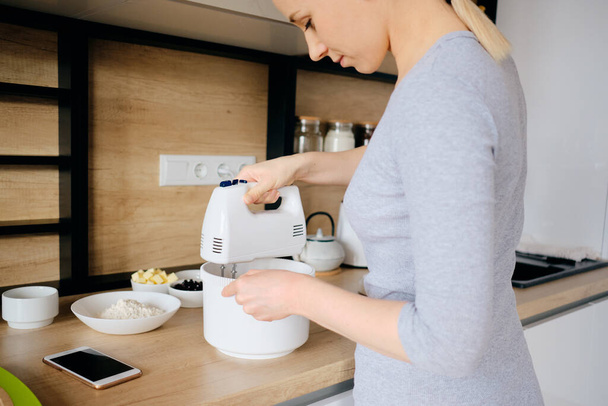 Authentic woman using a handheld mixer - Photo, Image